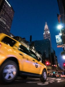 Photo en basse lumière à NYC : taxi jaune flou, Chrysler Building éclairé. Apprendre la photo en intérieur.