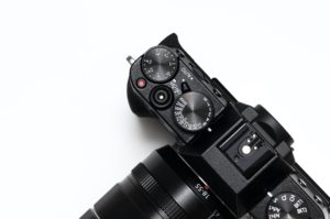 Détails d'un appareil photo argentique noir. Molettes de réglage, objectif 18-55mm. Quel appareil choisir?