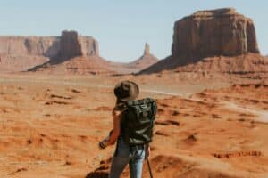 Femme avec sac photo en randonnée. Choisir son sac photo pour voyage et aventure.