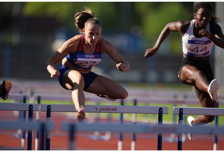 Athlète féminine sautant une haie lors d'une course. Sony A1 II, athlétisme, compétition sportive.