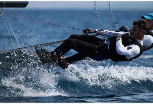 Voilier en action avec Sony A1 II : Deux marins naviguent rapidement, l'eau éclabousse, course maritime spectaculaire.