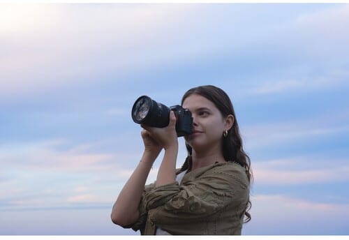 Femme photographiant avec un Sony A7 V. Photographie professionnelle, appareil photo hybride.