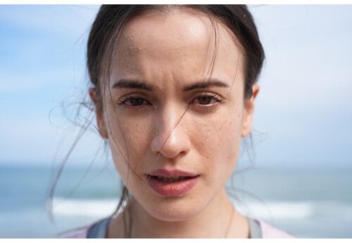 Portrait d'une femme sur la plage avec le Sony A7 V, peau avec du sable.