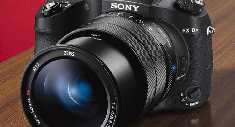 Sony RX10 IV vue de face sur table en bois. Appareil photo bridge haut de gamme avec objectif Zeiss Vario-Sonnar T*.