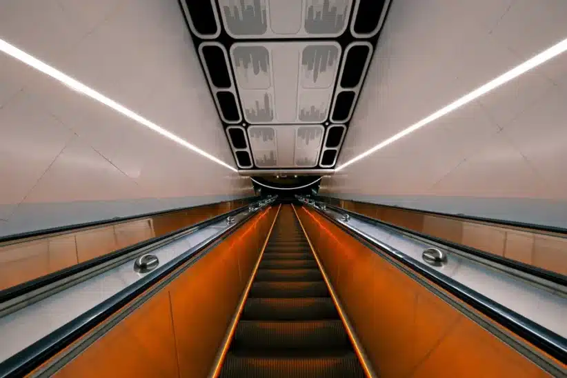 Escalier mécanique moderne avec éclairage orange, design architectural futuriste. Fujifilm X-T30 III, Dong-Yuan.