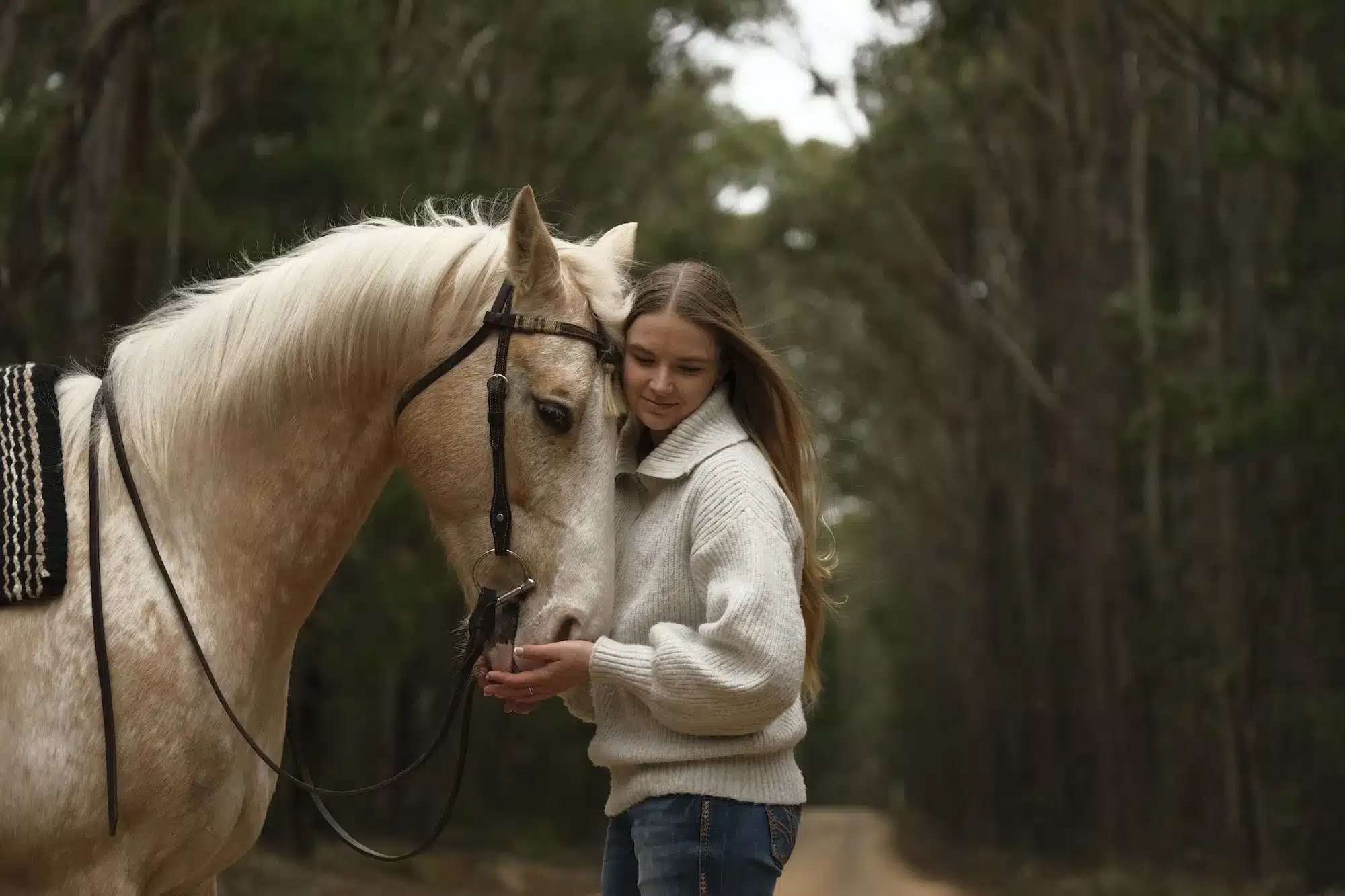 Une femme embrasse son cheval alezan dans la nature, capturée avec un Fujifilm X-T30 III.