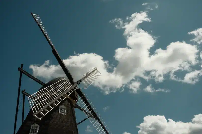 Moulin à vent traditionnel sous un ciel bleu nuageux, capturé avec un Fujifilm X-E5. Photographie de Yukio Uchida.