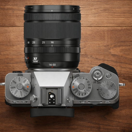 Appareil photo hybride Fujifilm XF Zoom 16-50 sur table en bois. Guide d'achat appareil photo en 2026.