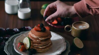 Photographie culinaire moody de pancakes aux fruits rouges et mûres. Guide pour sublimer vos plats.