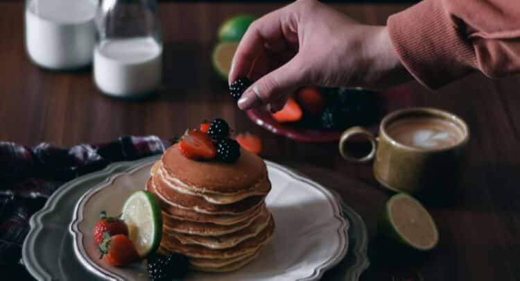 Photographie culinaire moody de pancakes aux fruits rouges et mûres. Guide pour sublimer vos plats.
