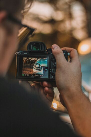 Choisir un appareil photo hybride : photo d'un photographe utilisant un appareil photo Sony pour photographier une voiture.