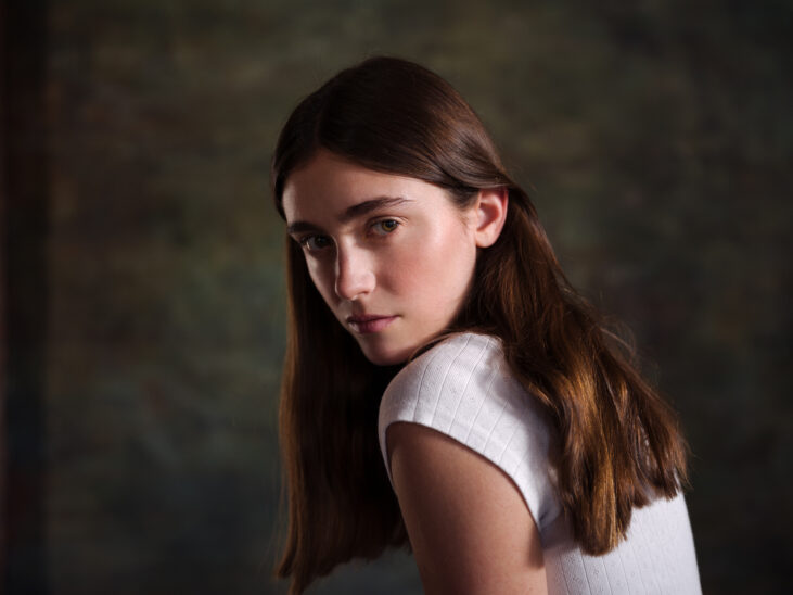 Portrait Hasselblad X2D II 100C&nbsp;: jeune femme regardant par-dessus son épaule, photographie moyen format, détail et netteté exceptionnels.