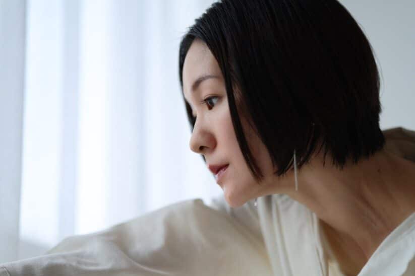 Portrait d'une femme aux cheveux courts près d'une fenêtre, en lumière douce