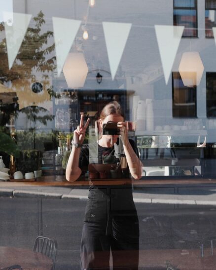 Photographe se prenant en photo dans le reflet d'une vitrine avec le Canon EOS R8 Mark II